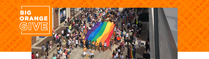 Photo of students carrying a rainbow flag