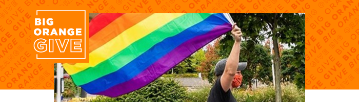 Photo of a student carrying a rainbow flag